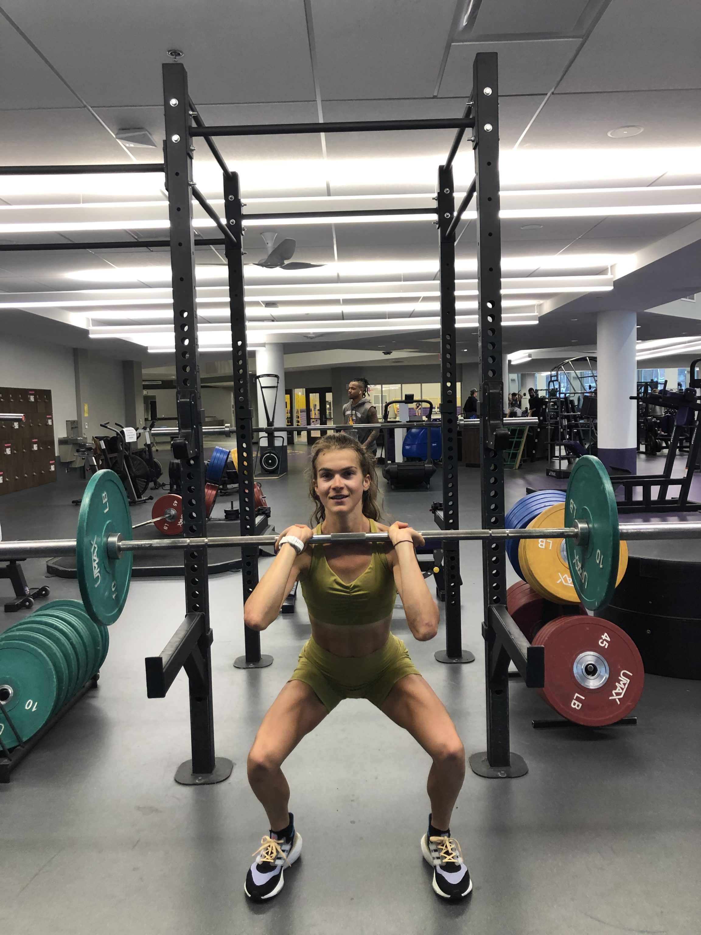A runner doing squats in the gym.
