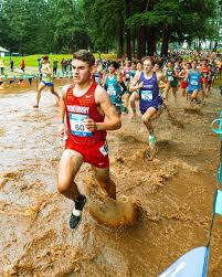 High school runners during a muddy cross country race.