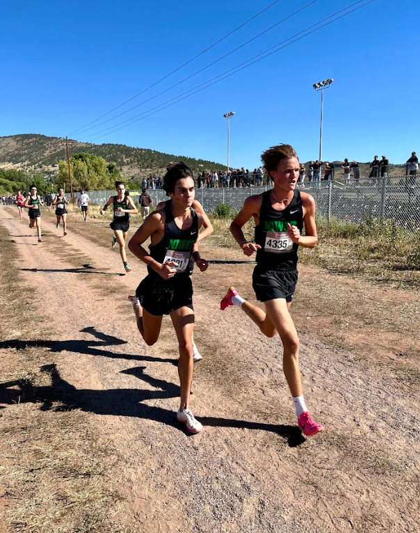 Young athletes running a hot cross country race.
